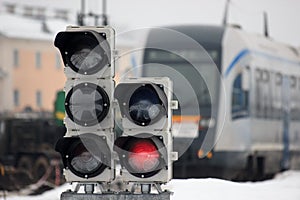 Railway traffic light on the background of a modern train. fast train at the railway station, will take to any part of the world.