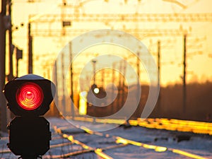 Railway traffic light shows blue signal on railway and railway with freight train as the background