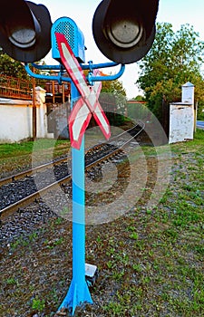 Railway traffic light and warning sign 1.3.1 Single track railway near white fence and railway track