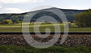 Railway train with meadow and Smrcina hill in Sumava mountains