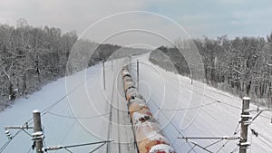 Railway train with tank cars in winter countryside