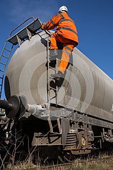 Railway Worker Climbing onto a Tanker Wagon