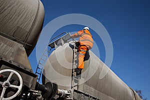 Railway Worker Climbing onto a Tanker Wagon