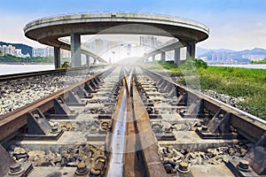 Railways track and bridge cross over with urban scene behind use