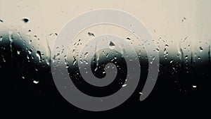 Rain background, thunderstorm outside the window, drops flow down the glass, abstract background of rain