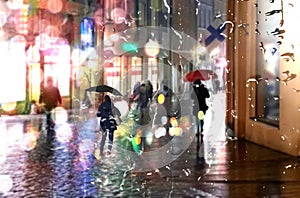 Rain city  autumn evening in city night light neon reflection rainy drops on wet pavement people walk with umbrellas in old town o
