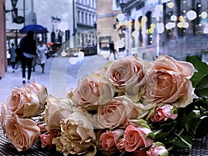 Rain in city people walk with umbrellas pink roses on cafe table street pink roses on cafe table in Tallinn old town Travel Estoni