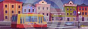 Rain on city street with houses and tram