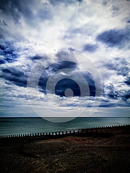 Rain clouds above empty beach and sea.