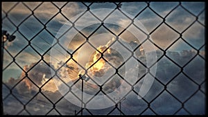 Storm clouds forming behind a wire fence