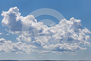 Rain clouds in bright sunlights on a blue sky