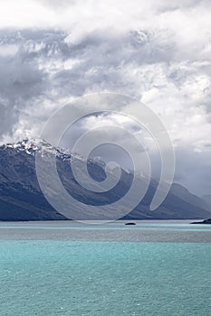 Rain clouds over snow-capped mountain. Wakatipu lake. New Zealand