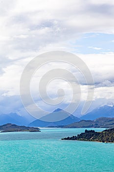 Rain clouds over the snow caps of the mountains. Wakatipu lake. New Zealand
