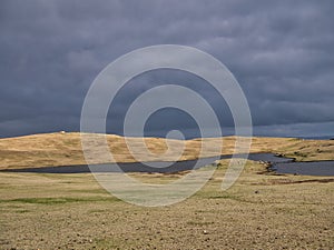 Before rain, dark clouds over a treeless landscape and lochen small lake in Eshaness, Shetland, UK photo