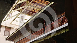 Rain drips from ancient temple roof at Sri Dalada Maligawa. Carved wood and intricate patterns adorn sacred site in