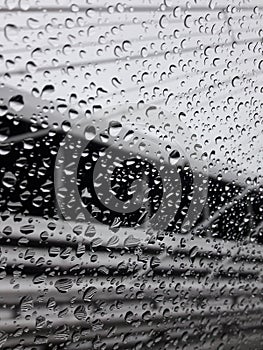 Rain drips covered side glass of moving car