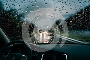 Rain drizzle on windshield in evening, driving in bad weather