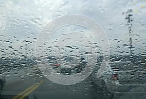 Rain drop on the car glass background.Road view through car window with rain drops, Driving in rain.