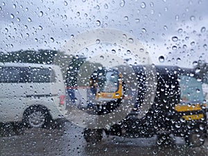 Rain drop on the car glass. Road TRAFFIC view through car window with rain drops, monsoon season in Maharashtra, India