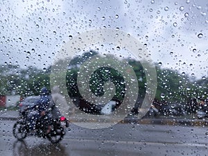 Rain drop on the car glass. Road TRAFFIC view through car window with rain drops, monsoon season in Maharashtra, India