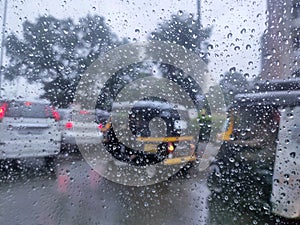 Rain drop on the car glass. Road TRAFFIC view through car window with rain drops, monsoon season in Maharashtra, India