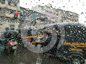 Rain drop on the car glass. Road TRAFFIC view through car window with rain drops, monsoon season in Maharashtra, India