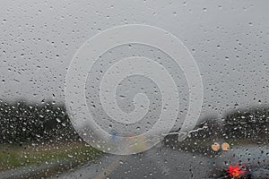 Rain drop on the cars windscreen . Abstract traffic in raining day. Road view through car window with rain .