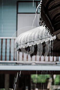 The rain drop flows down from a roof of house