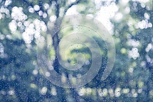 Rain drop on window glass with blur tree background, vintage col