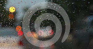 Rain drop on windshield with blur light of vehicle car on traffic jam
