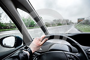 Rain droplet on car windshield. Driver in traffic on bad weather condition.