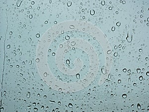 Rain droplets on a car`s window on a rainy day - driver`s perspective