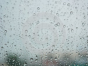 Rain droplets on a car`s window on a rainy day - driver`s perspective