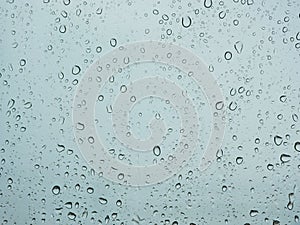 Rain droplets on a car`s window on a rainy day - driver`s perspective