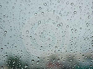 Rain droplets on a car`s window on a rainy day - driver`s perspective