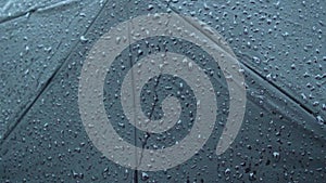 Rain Drops On Black umbrella. Extreme Close-up. Falling Rain drops on parasol. Abstract texture pattern. Rainy Season Nature