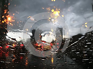 Rain drops on car front glass and bad traffic