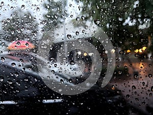 Rain drops on car window glass with blurred background