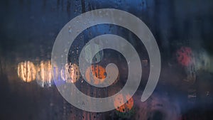 Rain Drops on Car Window Glass with Blurred Night City Car Lights Bokeh as Background. 4K.