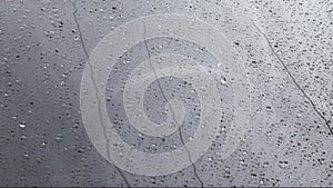 Rain drops on car windshield surface, closeup view from outside