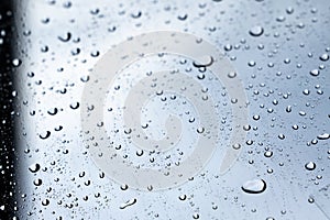 rain drops on clear glass wind screen of car , rain droplets