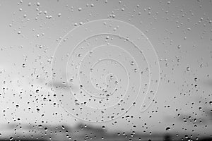 Rain drops and defocused sky background in black and white.