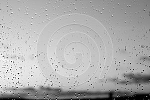 Rain drops and defocused sky background in black and white.