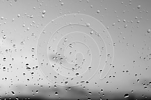 Rain drops and defocused sky background in black and white.