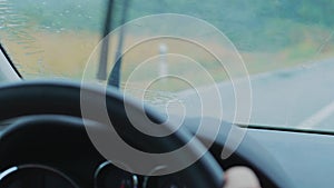 Rain drops on driving car front window, rain-sensing wipers