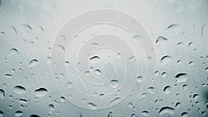 Rain drops on the electrically heated windshield of a car on a rainy day