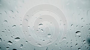 Rain drops on the electrically heated windshield of a car on a rainy day