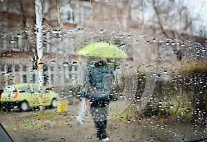 rain drops during falling rain and blurred man with umbrella