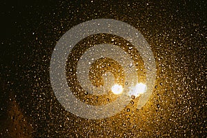 Rain drops on glass surface with bokeh night city lights from lanterns