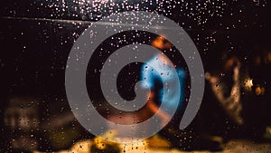 Rain Drops on glass window and man selling stuffs